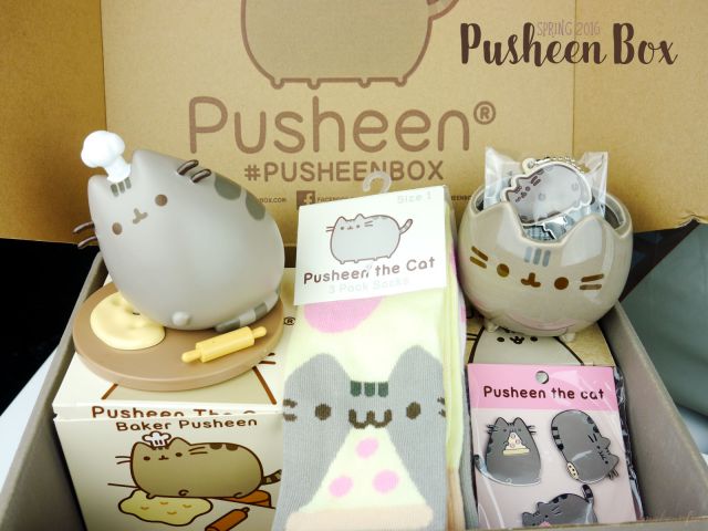Pusheen Box Spring 2016: Baker Pusheen vinyl figure, knee high socks set, ceramic planter, key cover, and 3-piece pin set.